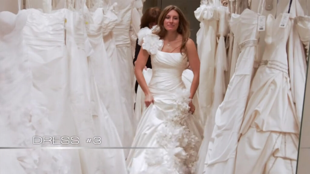 Bride Carly wears an uncomfortable heavy satin wedding dress chosen by her entourage