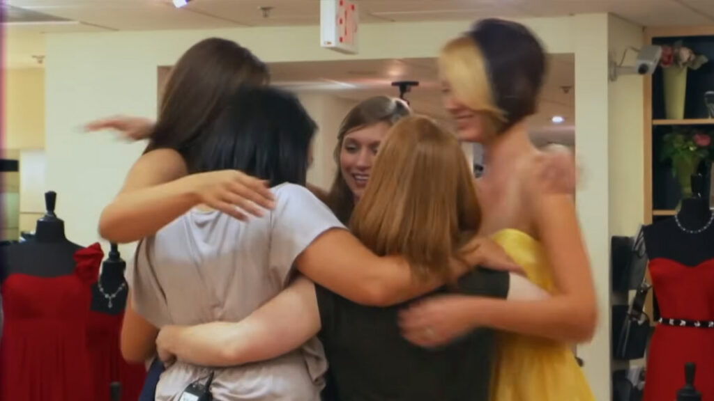 Bridesmaids comfort crying bride Emily during an emotional fitting at Kleinfeld