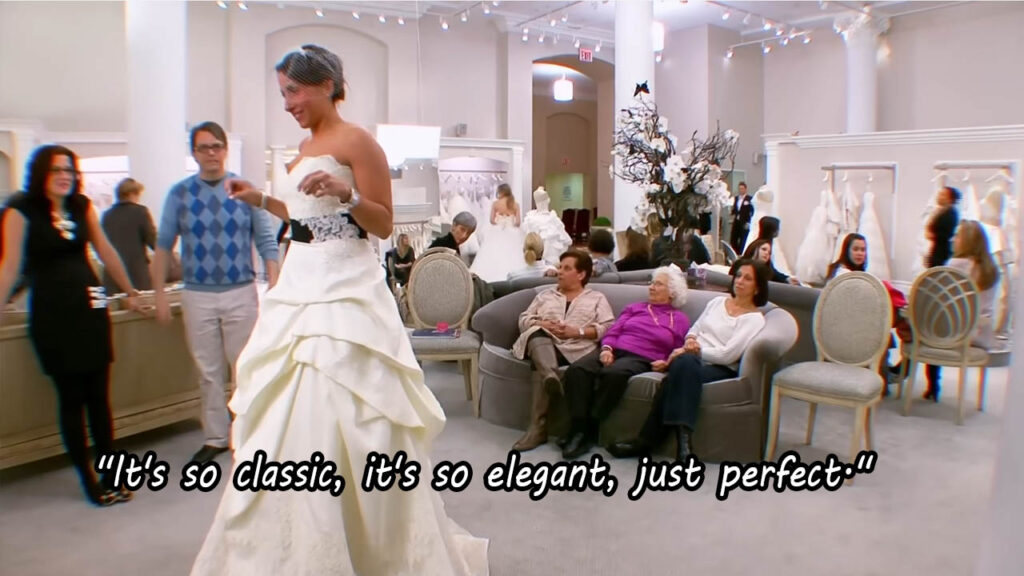 Bride trying on a unique designer wedding dress with a black belt.