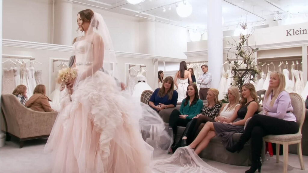 Bride buying a $9,000 colored designer wedding dress at a luxury boutique.