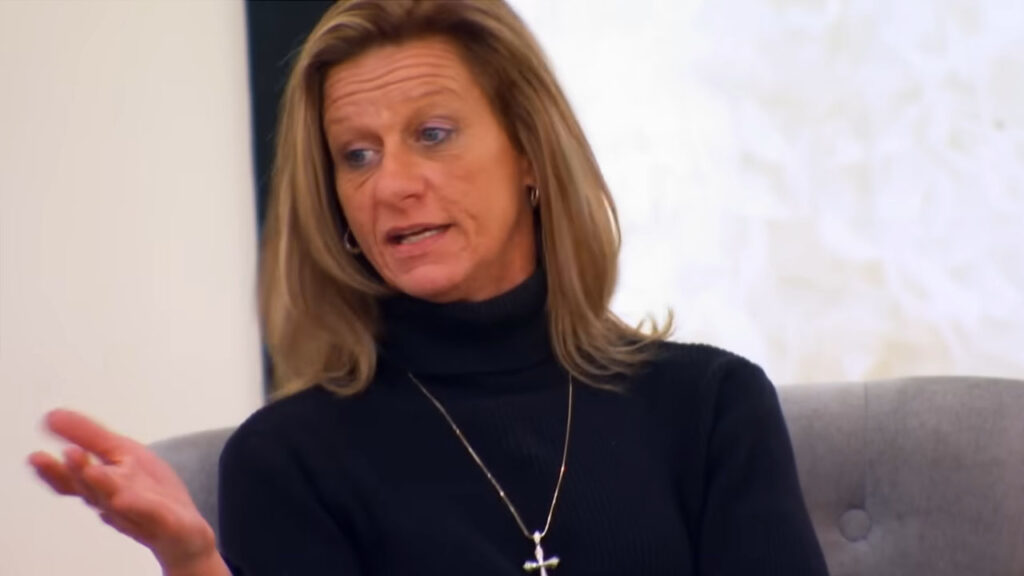 Emotional bride crying in her dream wedding dress while her mother disapproves.