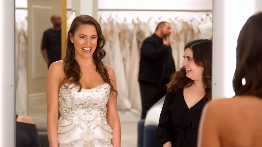 Bride showing off her snatched waist in a form fitting vintage bridal gown.