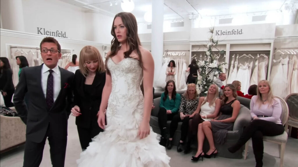 Bride trying on a sexy mermaid wedding dress but realizing she can't dance in it.