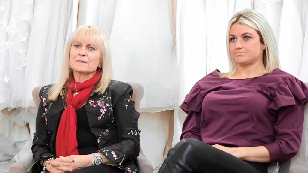 Disappointed toxic mother withholding her approval when the bride loves a modern fitted wedding dress.